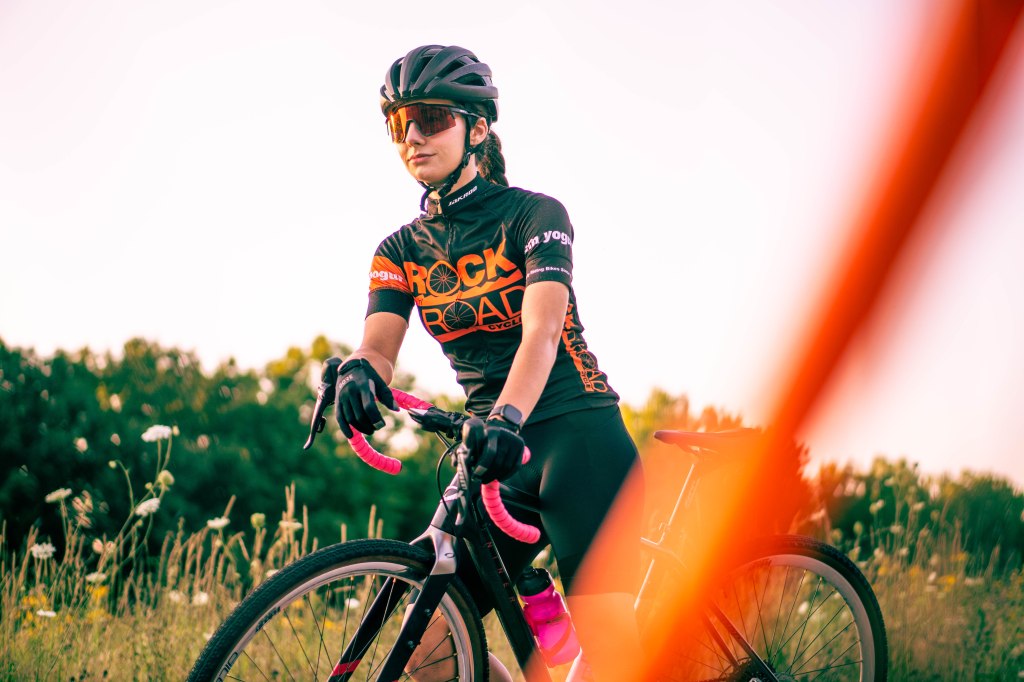 Maddy Rocks Rock and Road and rests on her bike.