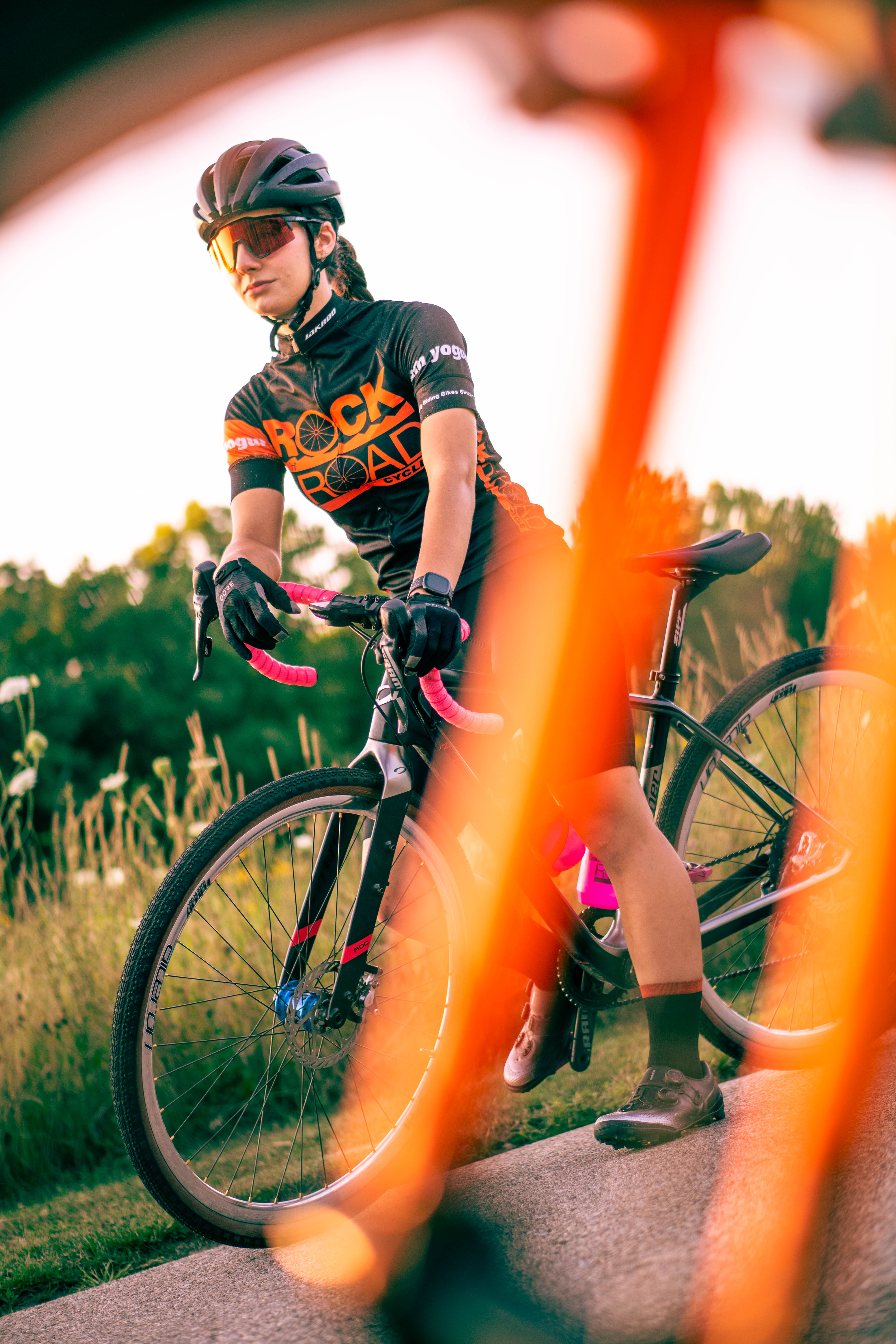 Maddy stops her bike and poses for a picture through bike spokes.